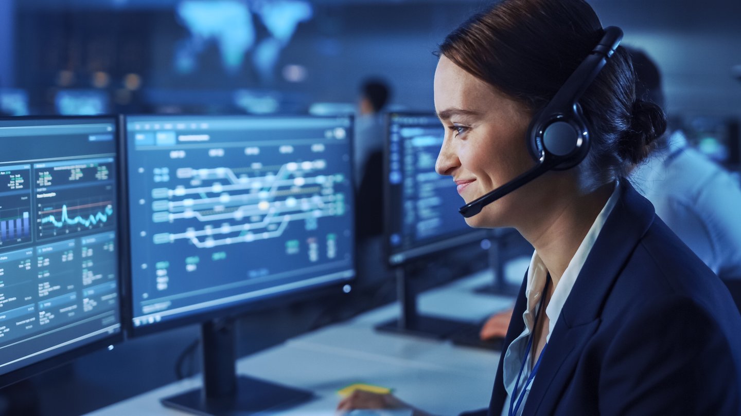 beautiful female customer service center employee working at a monitor in a mission control room